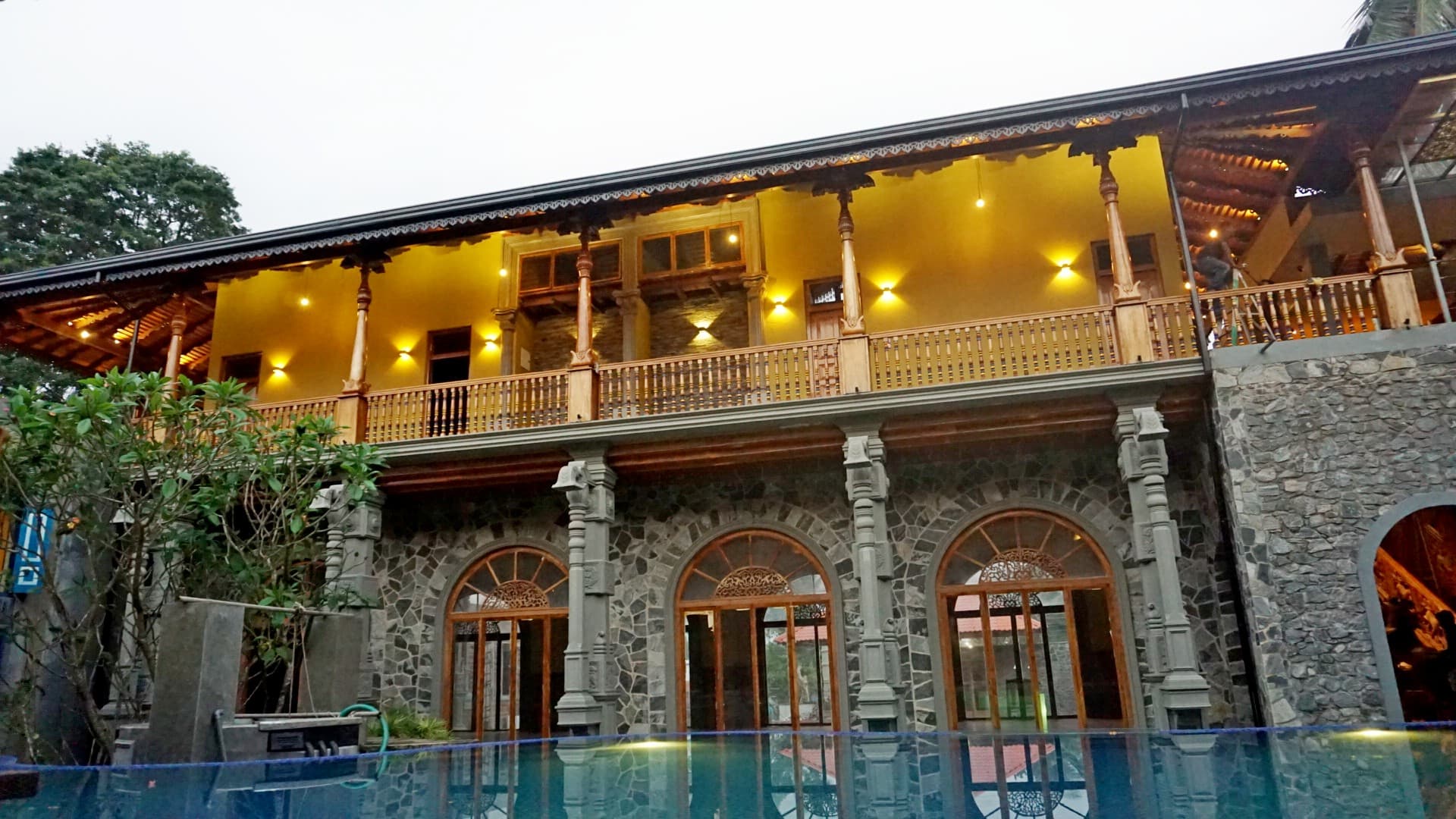 Heritage hotel exterior with pool at dusk